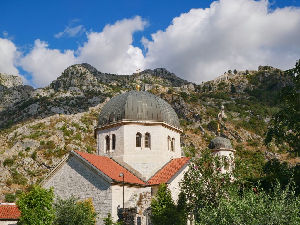 Picturesque church nestled against the rugged mountains of Kotor, Montenegro.